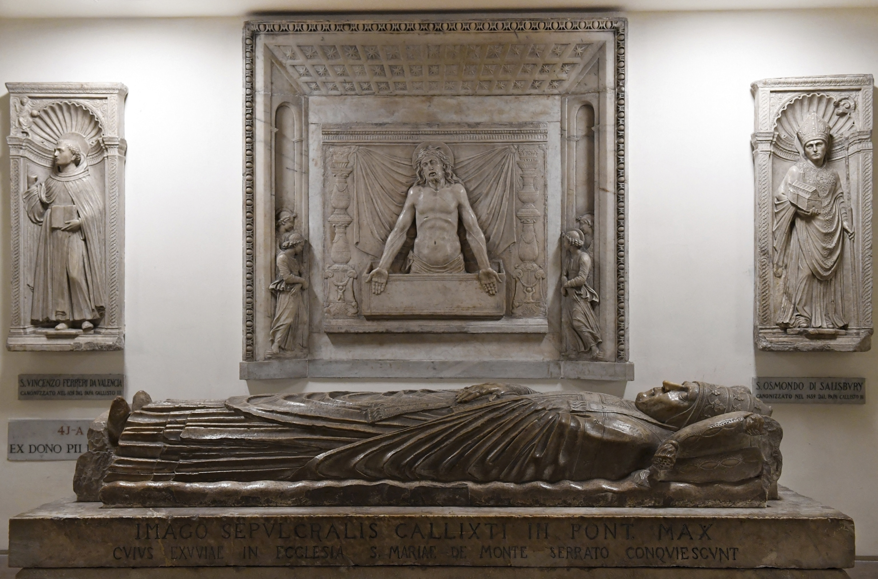 A sculpture of a deceased pope resting on top of a stone coffin.