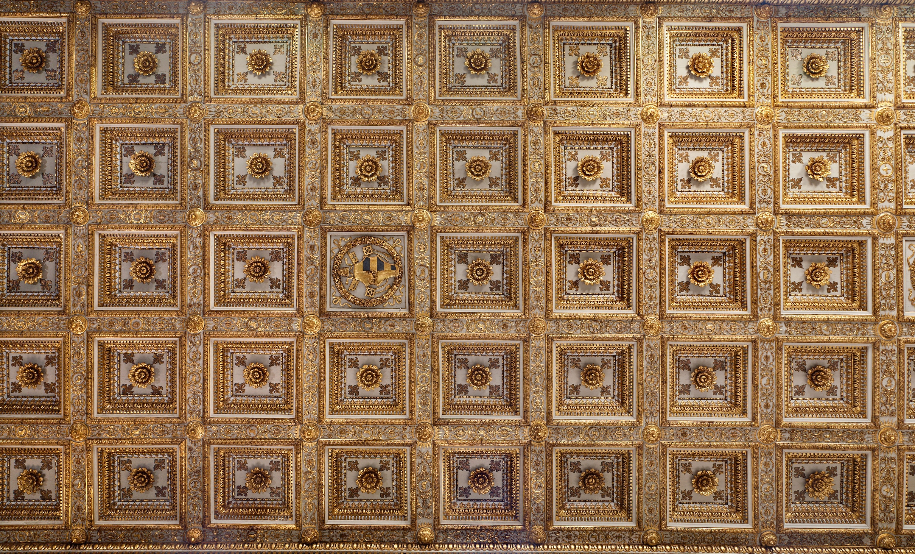 A photograph of a ceiling decorated with wood and gold inside of a basilica.