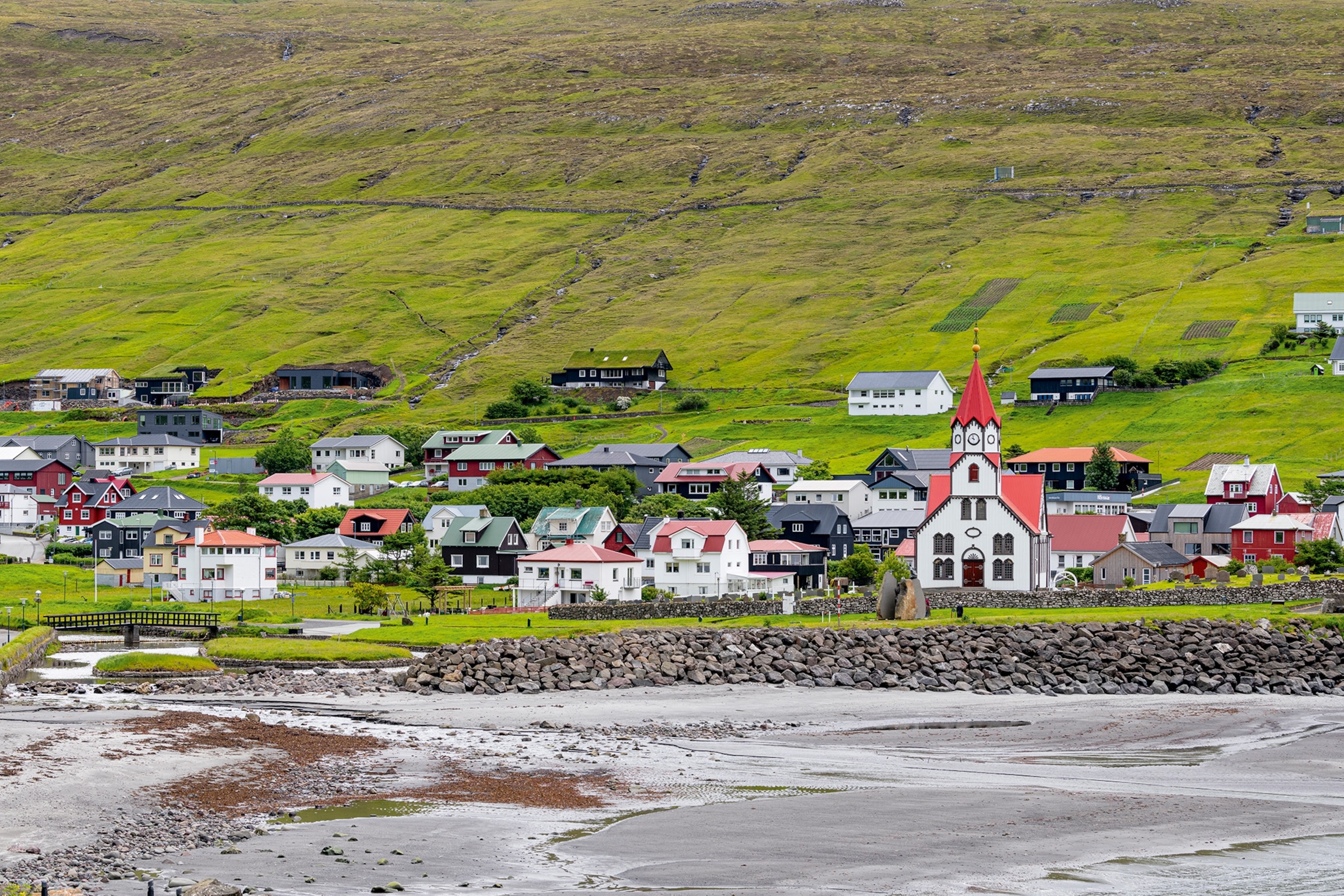 Sandavágur in the Faroe Islands has colourful houses surrounded by dramatic hills