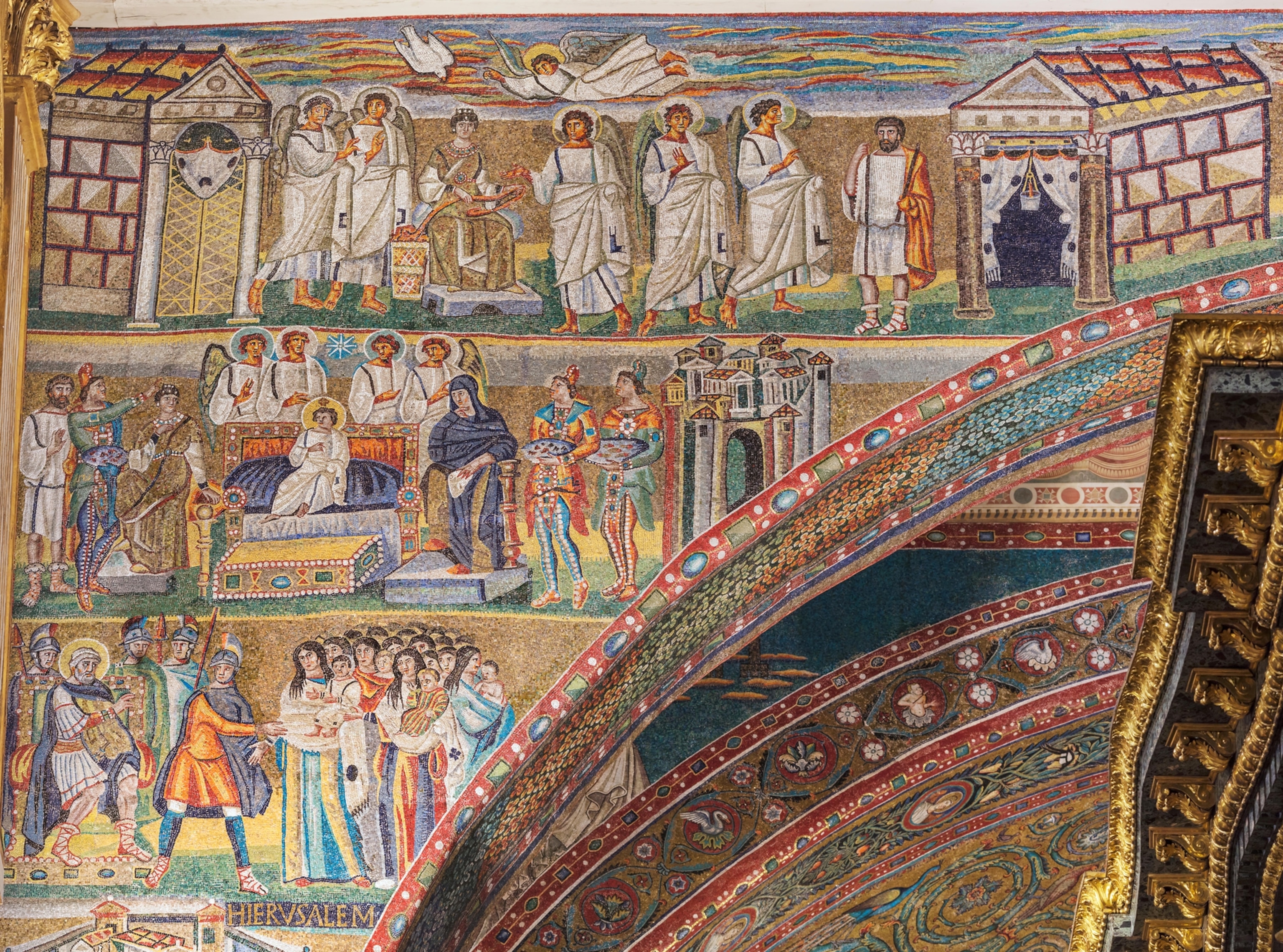 A close-up image of a colorful mosaic which shows depictions of people including saints and angels.