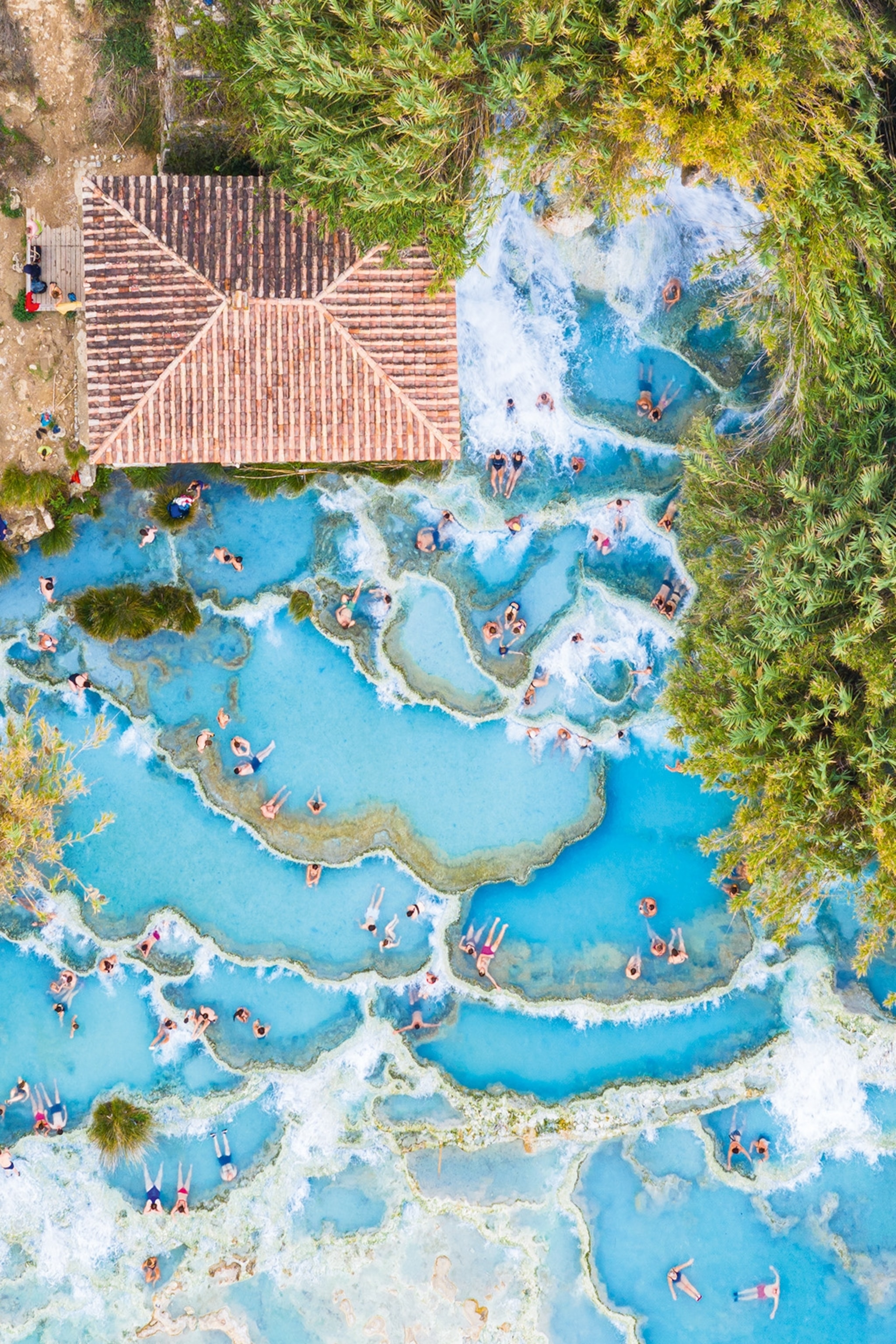 Aerial shot of visitors floating in Saturnia hot springs in Tuscany